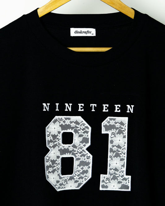 Black Martina Tee embroidered with Nineteen 81 in lace applique