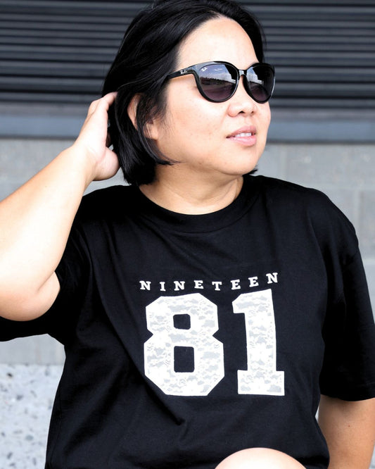 Black Martina Tee embroidered with Nineteen 81 in lace applique