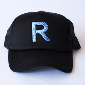 Black trucker hat with a variegated light blue 'R' on a white background