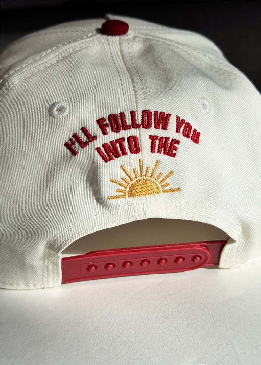 White cap with lyric and yellow sun embroidered at the back